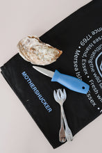 Load image into Gallery viewer, Oyster shucking tool, fork, and knife on a black towel with branding text.