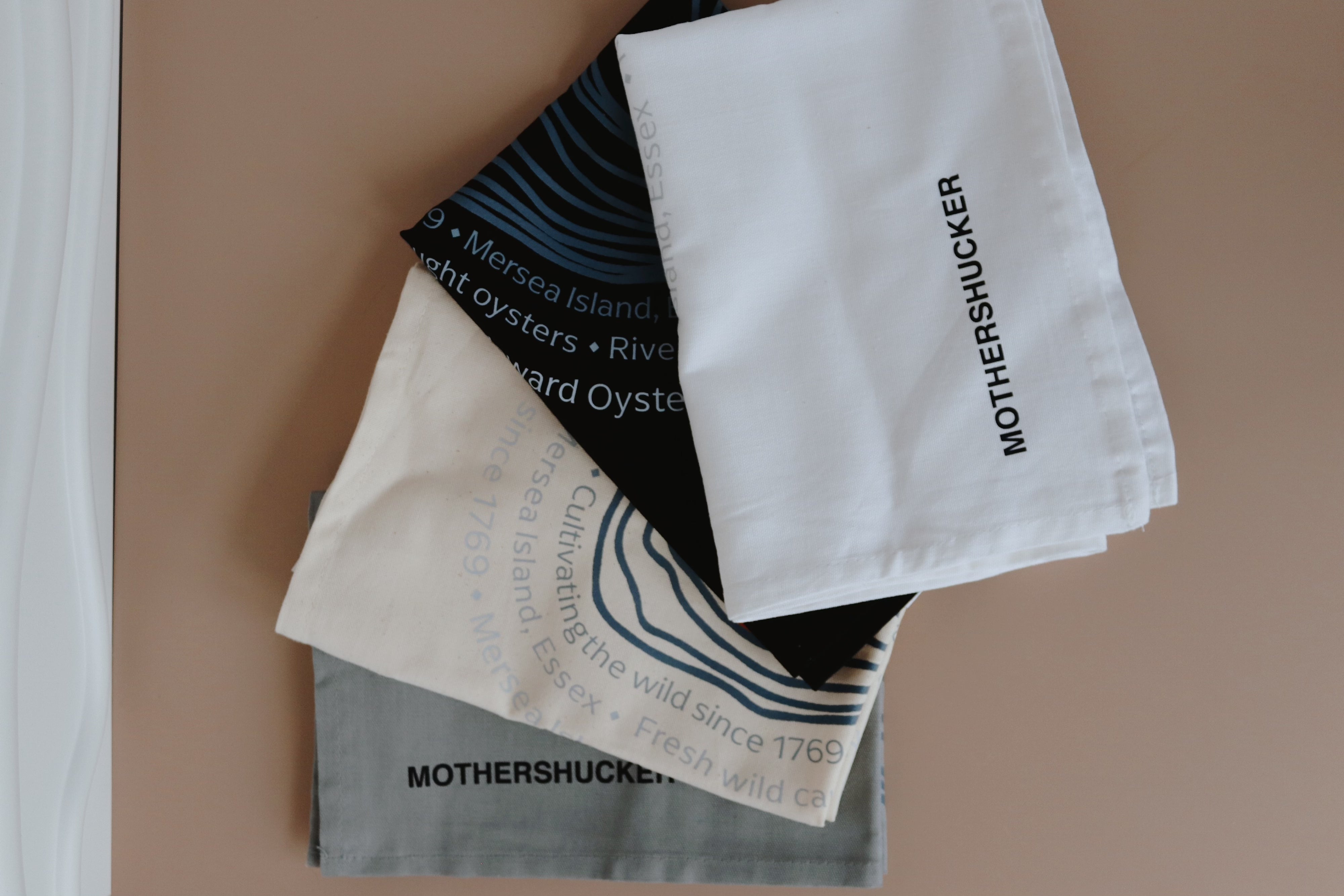 Stack of Mothershucker branded tea towels. Richard Haward's Oysters 