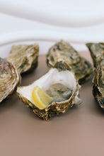 Load image into Gallery viewer, Open Jersey oyster with a lemon wedge on a plate
