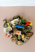 Load image into Gallery viewer, Jersey and Mersea Oysters on a half shell with lemon wedges and shucking tools on a beige background